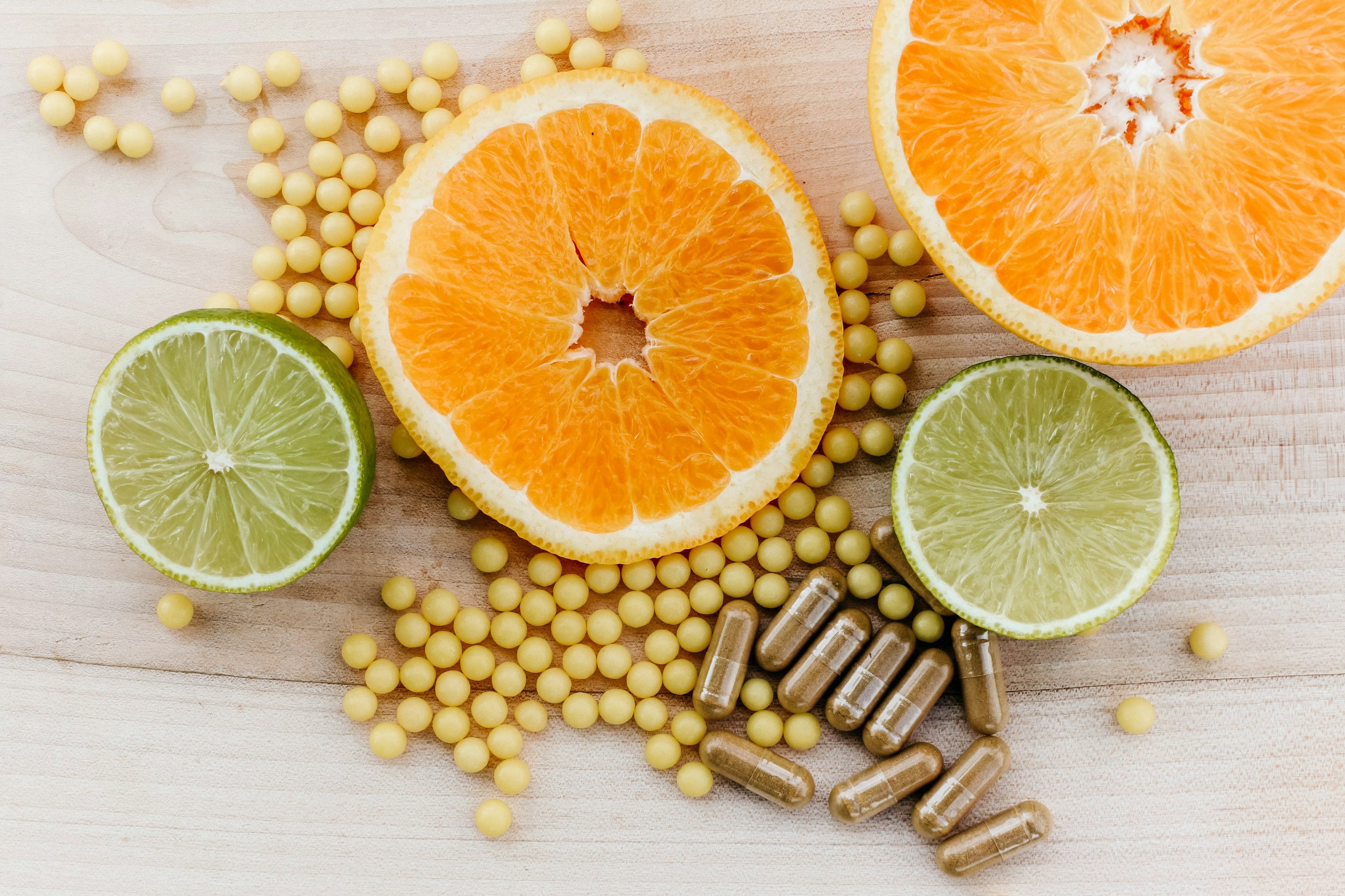 Wellness supplements and citrus on wood surface